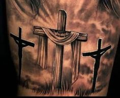 a man's back with three crosses on it and the sky in the background