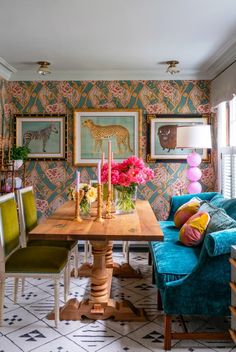 a living room filled with furniture and flowers on top of a wooden table in front of a window