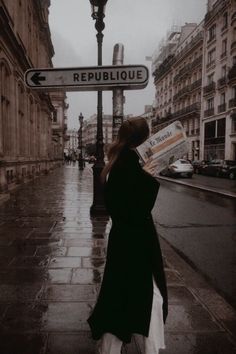 a woman is walking down the street with an umbrella