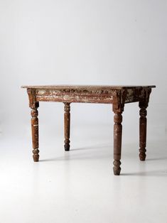 an old wooden table sitting on top of a white floor