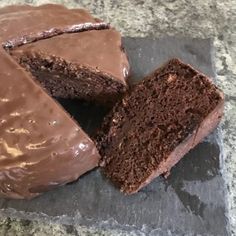 there is a piece of chocolate cake on the plate and one slice has been cut