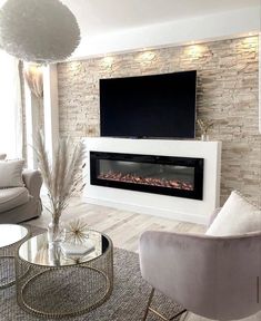 a living room with two chairs and a television mounted on the wall in front of it