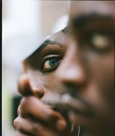 a close up of a man's face with his hands on his chin and eyes open