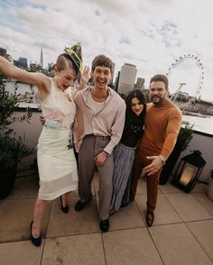 three people posing for a photo on a rooftop