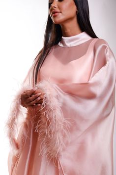 Wrap yourself in luxurious splendor with this stunning shimmer pink Organza maxi caftan dress, designed with ethereal butterfly sleeves with elegant feathers and a refined high neckline. A perfect choice for black-tie affairs, lavish resorts, wedding guests, or any occasion where timeless glamour is essential. Envision yourself gliding through a grand ballroom or strolling along an oceanfront terrace, the dress catching the light in the most alluring way. This caftan is your invitation to feel a Silk Kaftan With Cape Sleeves For Party, Elegant Feathered Maxi Dress, Pink Cape Sleeves Maxi Dress For Party, Pink Party Maxi Dress With Cape Sleeves, Pink Long Sleeve Dress With Feather Trim, Pink Maxi Dress With Cape Sleeves For Party, Evening Maxi Dress With Feather Trim, Pink Floor-length Party Kaftan, Pink Evening Kaftan For Spring