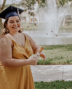 a woman wearing a graduation cap and gown is throwing confetti in the air