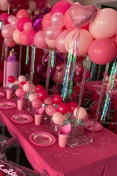 the table is set up with pink and white balloons