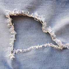 the back side of a pair of jeans with frayed edges and white stitchs