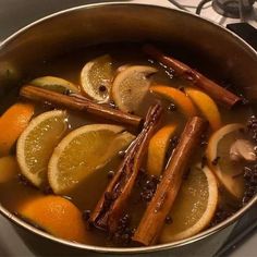 a pot filled with oranges and cinnamon sticks