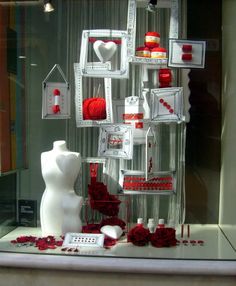 a display case with red and white items in the shape of hearts, flowers, and other things