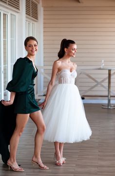 two women in short dresses standing next to each other