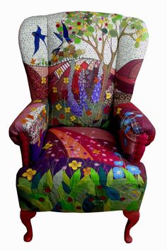 an upholstered chair with flowers and birds on it