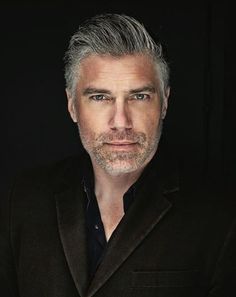 a man with grey hair wearing a black suit