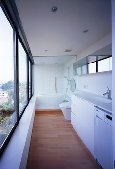 the bathroom is very large and has a glass wall to allow natural light into the room