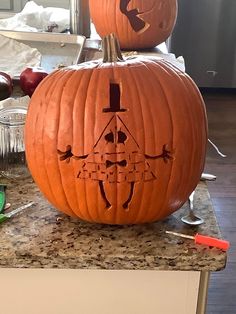 two carved pumpkins sitting on top of a counter next to each other with faces drawn on them