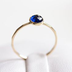 Tiny skinny stackable ring with beautiful deep blue Sapphire stone. It is made with a skinny but sturdy band, which allows you to create beautiful stacking sets! The ring is ideal for everyday wear and it will also look amazing with a festive dress.The ring is 0,8-0,9 mm thick and looks very dainty on the finger. Choose the finish of the stone (smooth cabochon or rose cut) and material for the ring (sterling silver or 9k gold).If you want to change the ring band design or get a custom ring or ri Minimalist Adjustable Sapphire Ring, Minimalist Sapphire Ring With Bezel Setting For Everyday, Minimalist Stackable Sapphire Ring, Everyday Stackable Sapphire Ring, Minimalist Blue Stackable Rings For Everyday, Dainty Stackable Sapphire Ring, Dainty Stackable Sapphire Birthstone Rings, Minimalist Stackable Round Band Sapphire Ring, Stackable Minimalist Sapphire Ring With Round Band