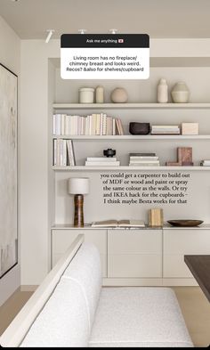 a living room filled with lots of white furniture and bookshelves on top of each other