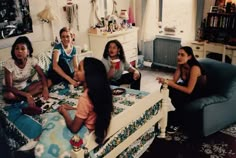 four women are sitting in a living room and one is talking to the other woman