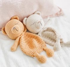 two crocheted stuffed animals laying next to each other on top of a bed