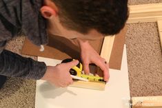 a young man is working with wood and glue