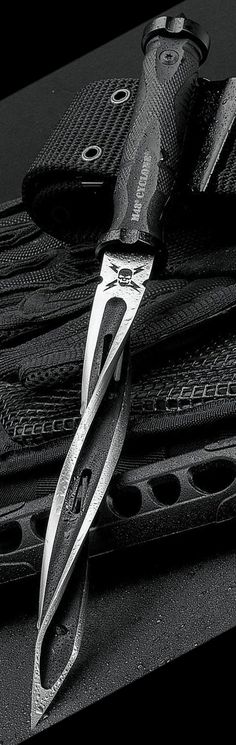 a black and white photo of a knife on top of some wallets that are tied together