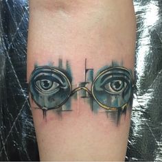 an eye tattoo on the leg of a person