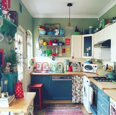 a kitchen filled with lots of clutter and colorful items on the shelves over the stove