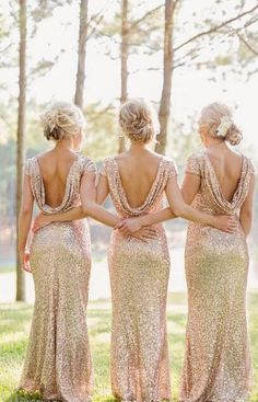 three women in gold dresses standing next to each other on a cell phone with the caption