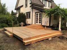 a wooden deck in front of a white house