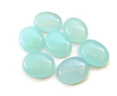 six light blue glass cabochles on a white background