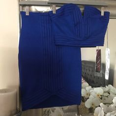 there is a blue dress hanging on a rack in front of a mirror with flowers