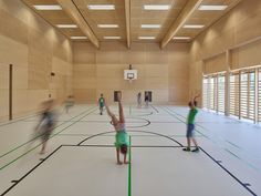 people are playing basketball in an indoor court with green lines on the floor and walls