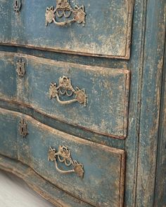 an old blue dresser with ornate handles and knobs