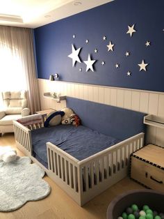 a child's bedroom with blue walls and white stars on the wall