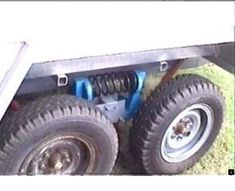 an image of the front wheels and tires of a trailer that is parked on grass