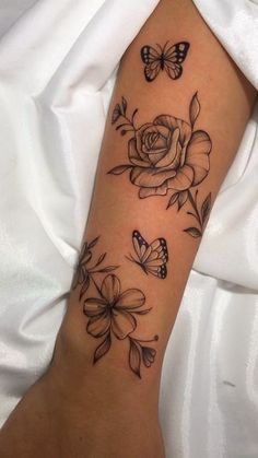 a woman's arm with flowers and butterflies on it