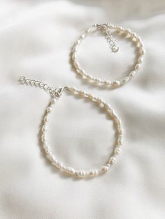 "Freshwater pearls are one of a kind so will differ from those shown in the photos.  ∙ S I Z E ∙ G U I D E ∙ We recommend that you take your own measurement before purchasing but if that is not possible, here is a rough size guide below.  Exchanges are always welcome if the fit is not perfect!   6\" - bracelet suitable for adults with small wrists  7\" - bracelet suitable for most adults   8\" - anklet suitable for adults with small ankles  9\" - anklet suitable for most adults 10\" - anklet suitable for adults with wider ankles    Each item comes with an additional 1\" extension chain on top of your selected length.    For example, if you select the 6\" option, the total length will be approximately 7\" including the clasp and extension chain.  M A T E R I A L S ∙    Durable steel cord, f Plain Beaded Bracelets, Minimalist Sterling Silver Pearl Bracelet With Charm, Minimalist Pearl White Beaded Bracelets With Pearl Charm, Handmade Pearl White Everyday Pearl Bracelet, Classic Handmade Pearl Bracelet For Everyday, Classic Handmade Pearl Bracelet, Delicate White Pearl Bracelet Hypoallergenic, Delicate White Pearl Bracelet Skin-friendly, Delicate White Hypoallergenic Pearl Bracelet