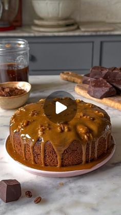 a chocolate cake with caramel drizzled on top sitting on a counter