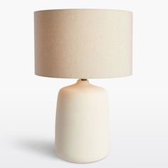 a white table lamp with a beige shade