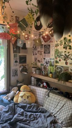 a bedroom with lots of stuffed animals on the bed and decorations hanging from the ceiling