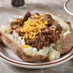 a white plate topped with potatoes covered in meat and cheese