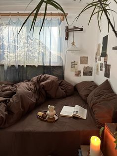 a bed sitting under a window next to a plant