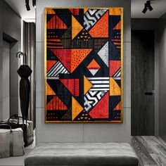 an abstract painting hangs on the wall above a couch in a living room with grey walls