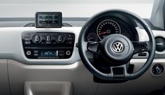 the interior of a car with red dash lights and steering wheel, dashboard controls and gauges