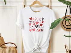 "Wrap your love in a vibrant embrace with our Heartful Harmony T-shirt! 🌈 Overflowing with joy, with the key features a kaleidoscope of brilliantly coloured hearts. Each colour signifies a unique moment, a cherished memory. Let your heart speak louder than words. Gift the magic of love. Wear the warmth, share the joy. Because every heartbeat deserves a celebration!  #HeartfulHarmony #LoveInEveryHue" ✨Sizing✨ Please note that the T-Shirt and its sizing is unisex. Please review the sizes in the l Printed Pink T-shirt As Gift, Pink Printed T-shirt As A Gift, Cute White T-shirt For Valentine's Day, Cute Heart Print T-shirt For Valentine's Day, Mother's Day Short Sleeve T-shirt With Heart Print, Mother's Day Graphic Tee Tops As Gift, Cute Printed T-shirt For Mother's Day, Heart Shaped Graphic T-shirt For Valentine's Day, Valentine's Day Gift T-shirt With Short Sleeves