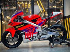 a red motorcycle parked inside of a garage