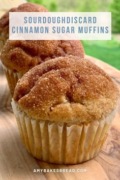 two cinnamon sugar muffins sitting on top of a wooden cutting board with the words sourdoughsicard cinnamon sugar muffins