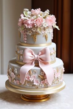 a three tiered cake with pink flowers and bows