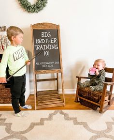 two small children standing in front of a big brother training 101 chalkboard and chair