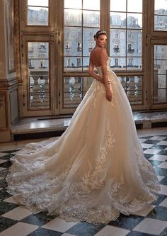 a woman in a wedding dress standing on a checkered floor with windows behind her